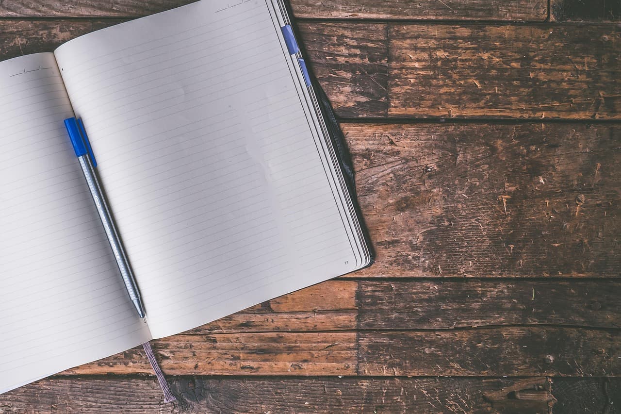 Blank journal open on a warm wooden desk, ready for writing