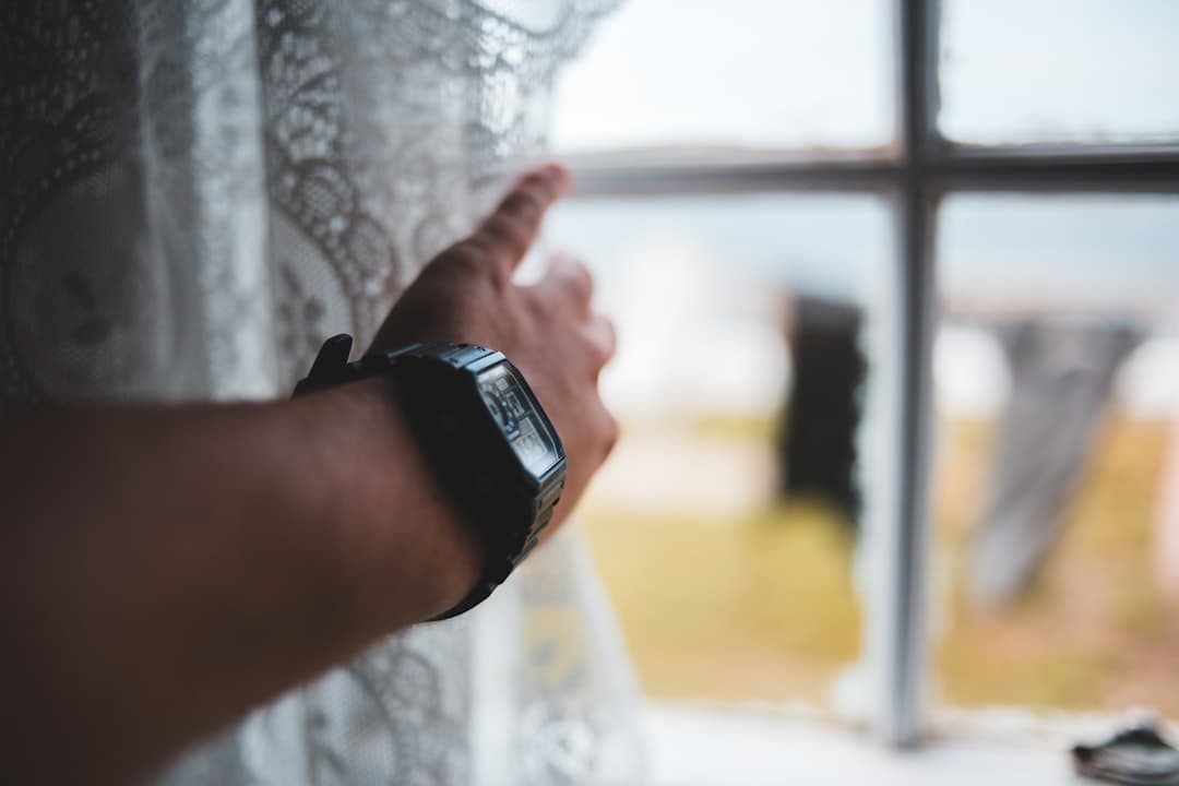 A person's wrist wearing a digital smartwatch, lit by soft natural daylight