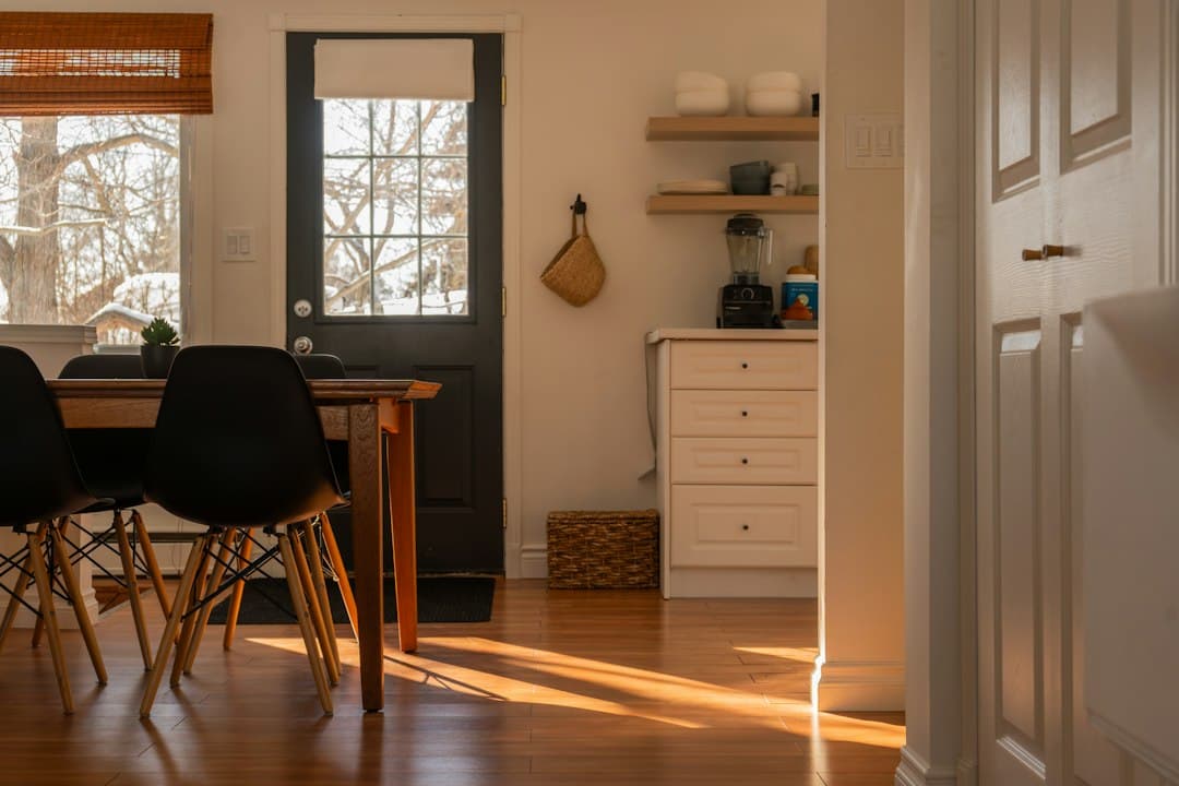 Morning sunlight coming through a window into a quiet kitchen and dining area