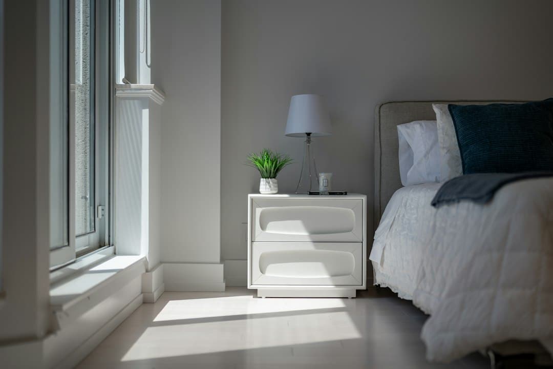 Morning sunlight falling across a cozy bedroom with a bed and nightstand