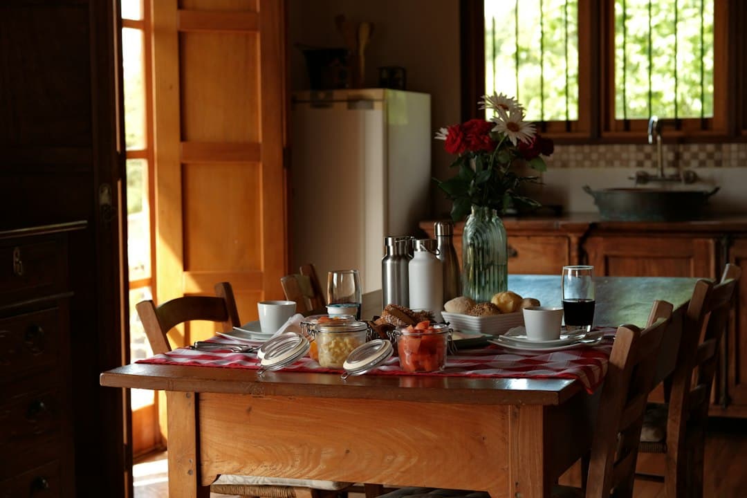 A breakfast table set with food and drinks in a sunlit kitchen