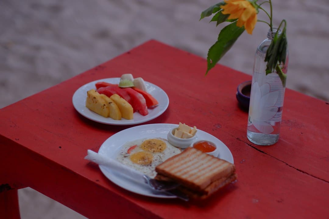 A table set with breakfast and a bowl of fruit salad
