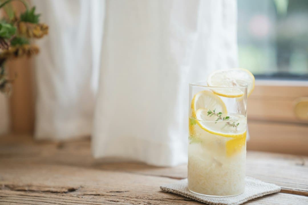 A clear glass of water with a slice of lemon